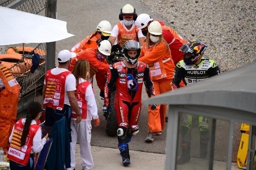 Andrea Dovizioso (kiri) terlihat kesal karena gagal melanjutkan balap MotoGP Catalunya, Minggu (27/9/2020), usai ditabrak Johann Zarco. [AFP]