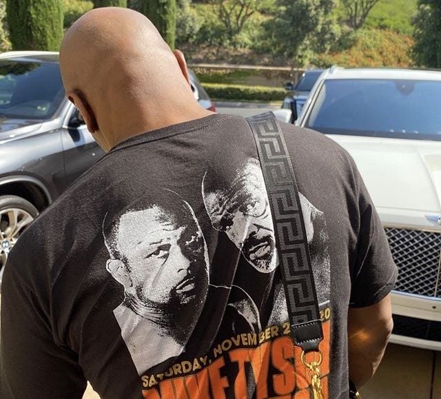 Kaos atau t-shirt dengan punggung bertuliskan jadwal balapan. Simak Rolls-Royce di sisi kanannya [Instagram: miketyson].