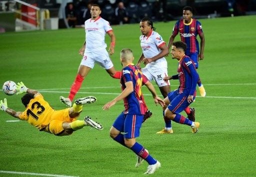 Pemain Barcelona Philippe Coutinho menjebol gawang Sevilla dalam pertandingan di Camp Nou, Senin (5/10/2020). [AFP]