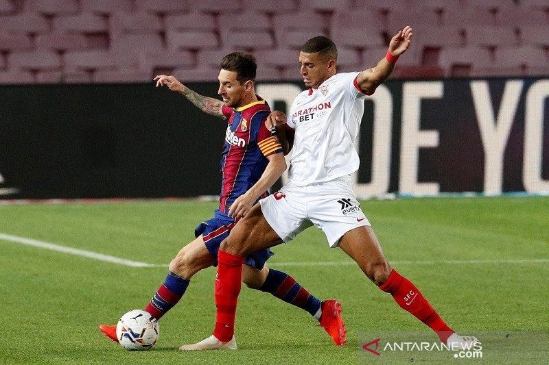 Bek Sevilla Diego Carlos (kanan) berusaha merebut bola dari penguasaan megabintang Barcelona Lionel Messi dalam lanjutan Liga Spanyol di Stadion Camp Nou, Barcelona, Spanyol, Minggu (4/10/2020) waktu setempat. (ANTARA/REUTERS/Albert Gea) 