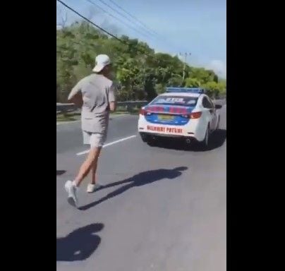 Mobil PJR kawal pria mirip Richard Muljadi joging di Bali. (Twitter)