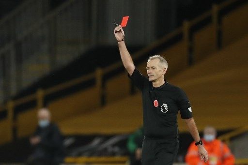 Wasit Martin Atkinson mengeluarkan kartu merah bagi pemain Crystal Palace Luka Milivojevic setelah melanggar pemain Wolverhampton dalam pertandingan Liga Premier Inggris yang berlangsung di Mollineux Stadium, Sabtu (31/10/2020). [AFP]