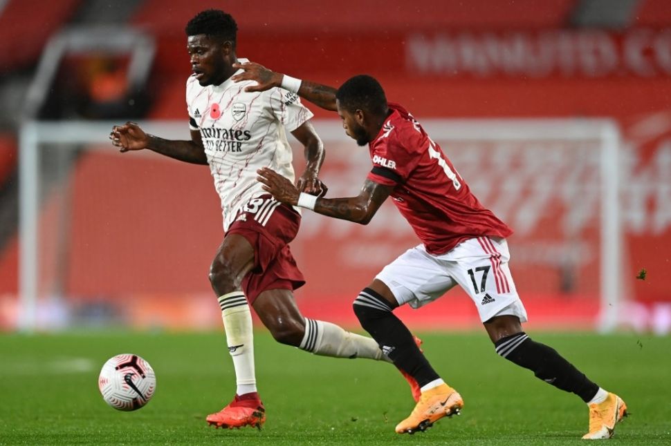 Gelandang Manchester United Fred (kanan) berebut bola dengan pemain Arsenal, Thomas Partey dalam laga lanjutan Liga Inggris, di Old Trafford, Manchester, Senin (2/1/2020) dini hari WIB. [Shaun Botterill / POOL / AFP]