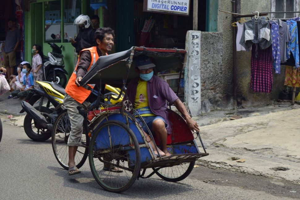 Terciduk tak pakai masker, warga di Pondok Ranji, Ciputat Timur, Kota Tangsel disanksi jadi tukang becak, Rabu (4/11/2020). (Suara.com/WIvy