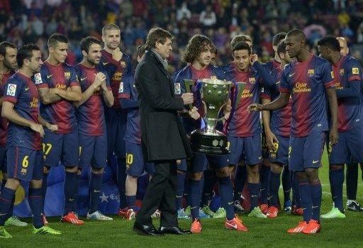 Pelatih Barcelona Tito Vilanova bersiap mengangkat trofi La Liga bersama Eric Abidal pada tahun 2013. [AFP]