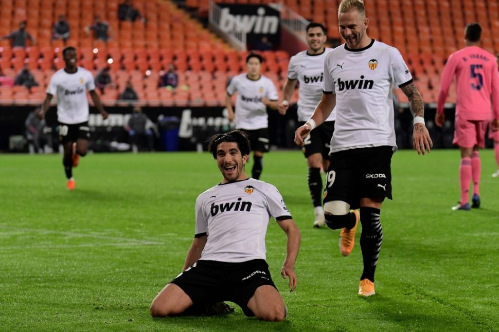 Gelandang Valencia, Carlos Soler (tengah) melakukan selebrasi usai mencetak gol menghadapi Real Madrid di laga lanjutan Liga Spanyol, di Stadion Mestalla, Valencia, Senin (9/11/2020) dini hari WIB. [JOSE JORDAN / AFP]