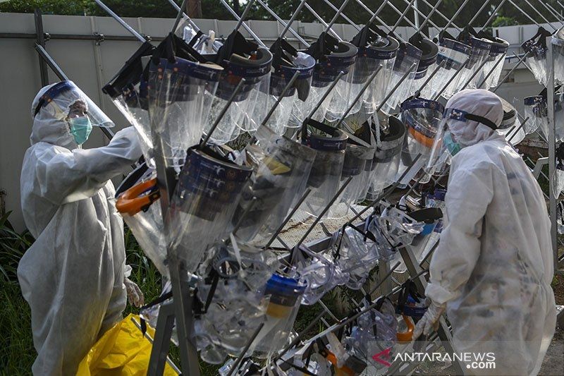 Sejumlah petugas tenaga kesehatan menjemur pelindung wajah yang telah didekontaminasi di Rumah Sakit Darurat Covid-19 Wisma Atlet Kemayoran di Jakarta, Kamis (12/11/2020). [ANTARA FOTO/M Risyal Hdayat]