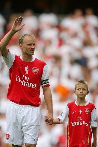 Dennis Bergkamp menggandeng putranya Mitchel jelang pertandingan Arsenal melawan Ajax di laga testimoni sang legenda di hari pembukaan markas baru The Gunners Emirates Stadium pada tahun 2006. [AFP]