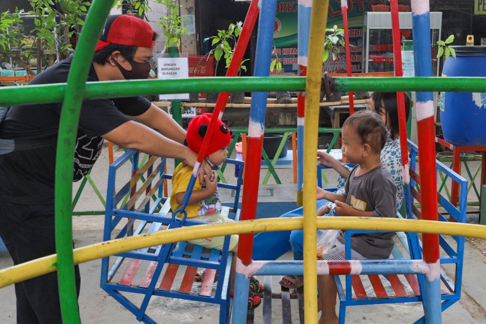 Anak - anak bermain dengan diawasi orang tua di Taman Bermain yang ada di Kolong Jalan Layang Rawajati, Jakarta Selatan, Kamis (19/11). [Suara.com/Alfian Winanto]