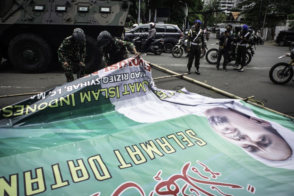 Prajurit TNI menurunkan spanduk bergambar Habib Rizieq Shihab saat patroli keamanan di Petamburan, Jakarta, Jumat (20/11/2020).  [ANTARA FOTO/Aprillio Akbar]