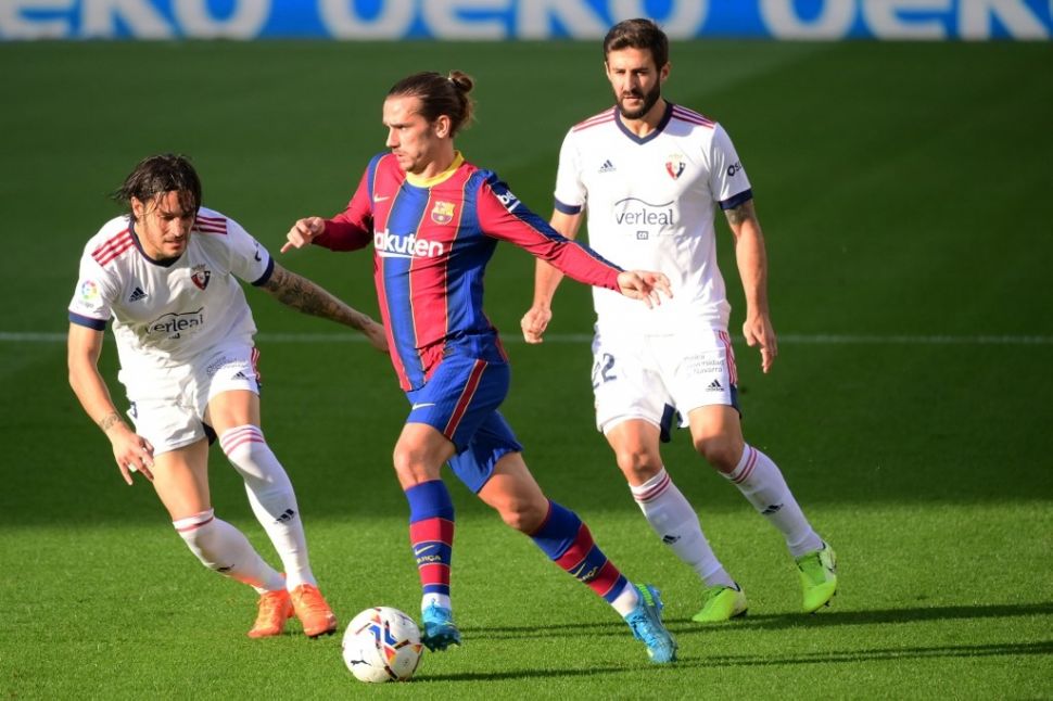 Penyerang Barcelona Antoine Griezmann coba melewati hadangan bek Osasuna Raul Navas dalam laga pekan ke-11 Liga Spanyol di Camp Nou, Minggu (29/11/2020). [LLUIS GENE / AFP]