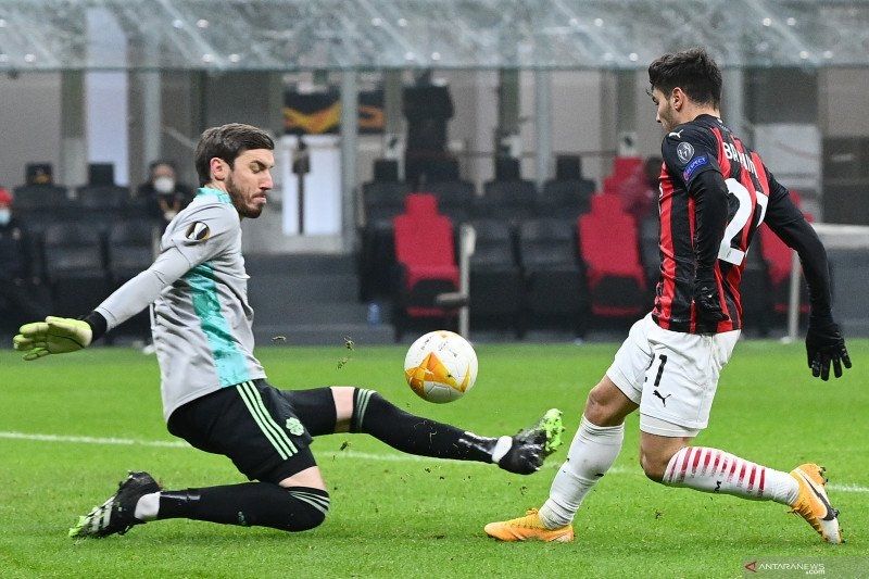 Gelandang AC Milan Brahim Diaz (kanan) menyepak bola melewati kiper Celtic Vasilios Barkas pada pertandingan Grup H Liga Europa yang dimainkan di Stadion San Siro, Milan, Kamis (3/12/2020). (ANTARA/AFP/VINCENZO PINTO)