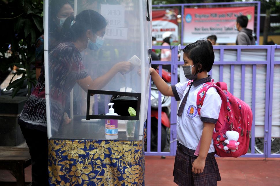 Guru memeriksa suhu tubuh siswa sebelum memasuki kelas saat simulasi pembelajaran tatap muka di SD Widiatmika, Jimbaran, Badung, Bali, Selasa (8/12/2020). [ANTARA FOTO/Fikri Yusuf]