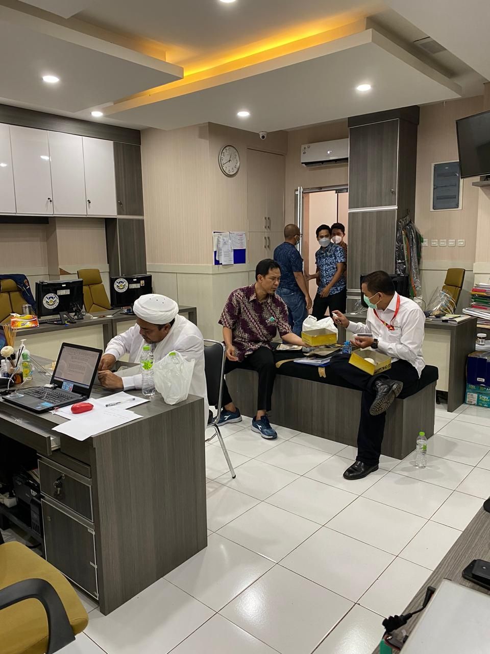 Habib Rizieq Shihab sedang makan saat menjalani pemeriksaan sebagai tersangka dalam kasus dugaan pelanggaran protokol kesehatan, Sabtu (12/12/2020) malam. [dokumentasi]