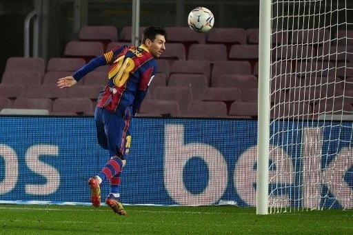 Pemain Barcelona Lionel Messi menyundul bola dalam pertandingan La Liga kontra Levante di Camp Nou, Senin (14/12/2020). [AFP]