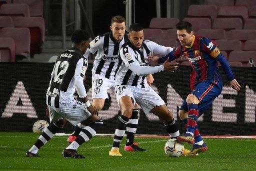 Pemain Barcelona Lionel Messi dihalau tiga pemain Levante dalam pertandingan La Liga di Camp Nou, Senin (14/12/2020). [AFP]