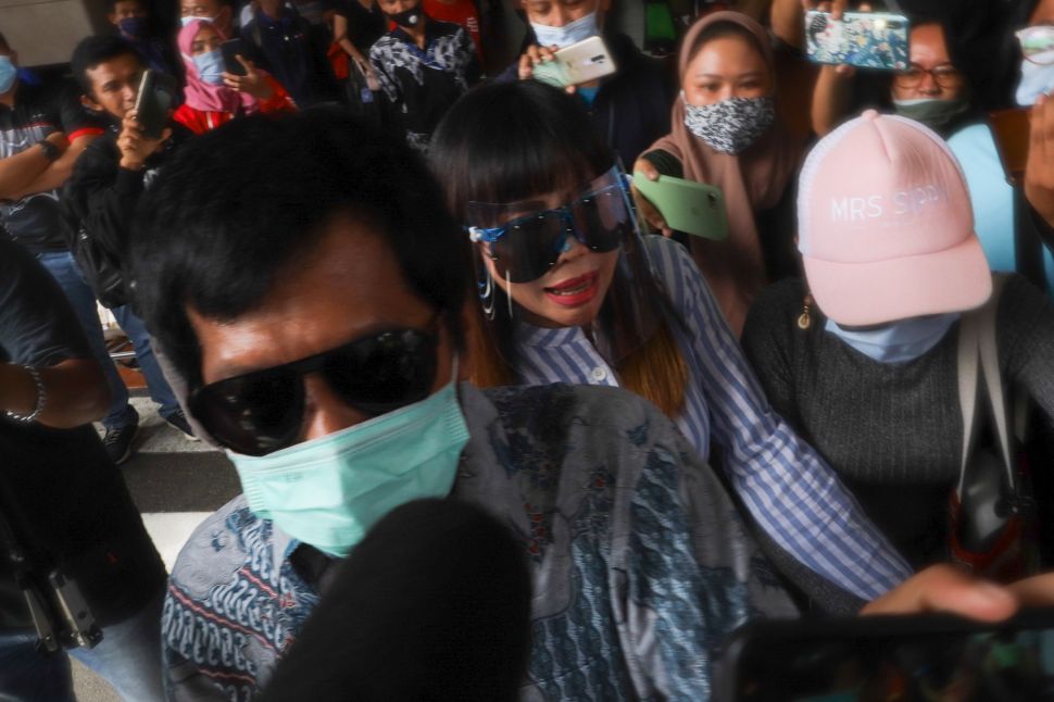 Komedia Kiwil bersama dengan istri mudanya, Eva Bellissima mencoba menghindari awak media saat tiba di Terminal 2 Bandara Soekarno Hatta, Tangerang, Banten, Rabu (16/12). [Suara.com/Alfian Winanto]