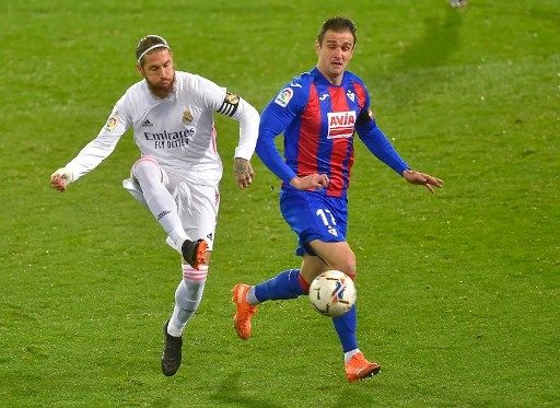 Pemain Real Madrid Sergio Ramos berebut bola dengan pemain Eibar dalam pertandingan La Liga yang berlangsung di Estadio Municipal de Ipurua, Senin (21/12/2020). [AFP]