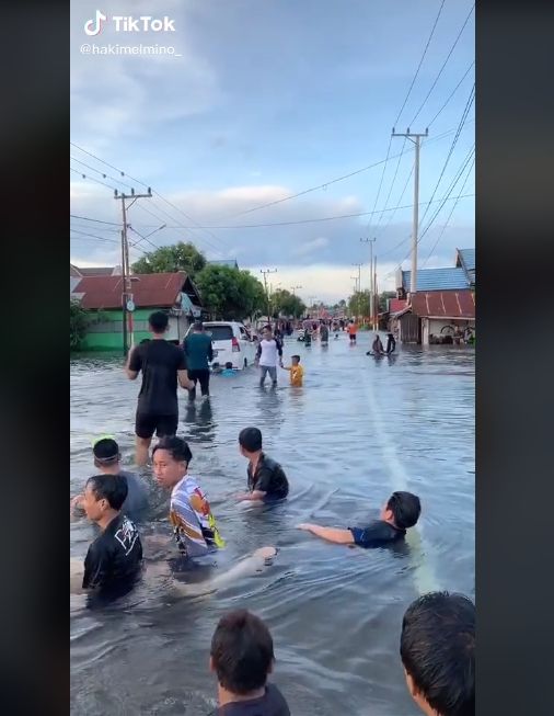 Video warga asyik main air saat banjir. (TikTok/hakimelmino_)