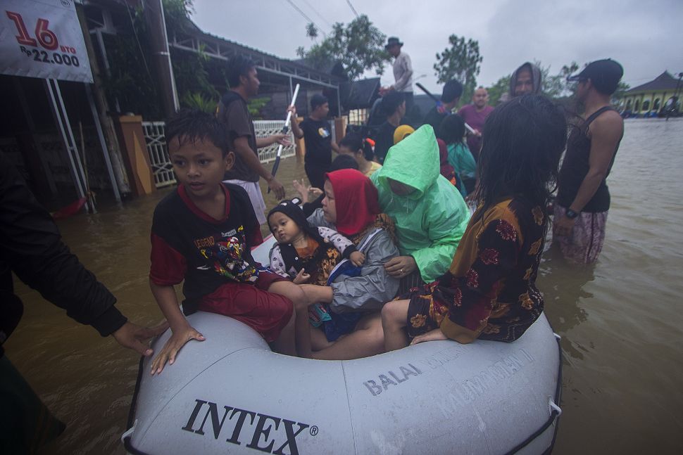 Sejumlah relawan menggunakan perahu karet membantu evakuasi warga yang terdampak banjir di Desa Kampung Melayu, Kabupaten Banjar, Kalimantan Selatan, Jumat (15/1/2021). [ANTARA FOTO/Bayu Pratama S]