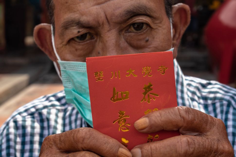 Warga lanjut usia (lansia) menunjukkan angpau yang diterimanya dari Yayasan Kelenteng Tay Kak Sie, Semarang, Jawa Tengah, Jumat (22/1/2021).  [ANTARA FOTO/Aji Styawan]