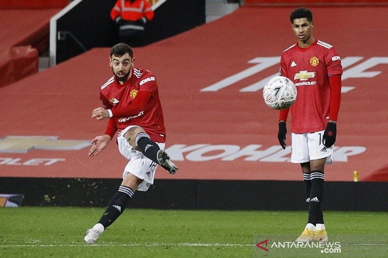 Gelandang Manchester United Bruno Fernandes (kiri) mengeksekusi tendangan bebas untuk mencetak gol kemenangan atas Liverpool dalam laga putaran keempat Piala FA di Stadion Old Trafford, Manchester, Inggris, Minggu (24/1/2021) waktu setempat. (ANTARA/REUTERS/POOL/Phil Noble)