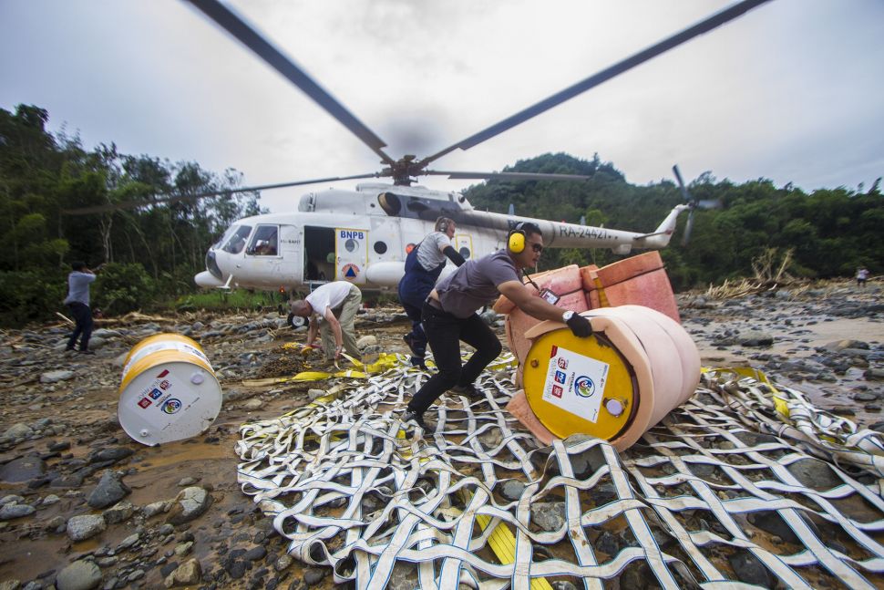 Petugas menurunkan logistik bantuan bahan bakar minyak (BBM) di Desa Datar Ajab, Kabupaten Hulu Sungai Tengah, Kalimantan Selatan, Kamis (28/1/2021). [ANTARA FOTO/Bayu Pratama S]