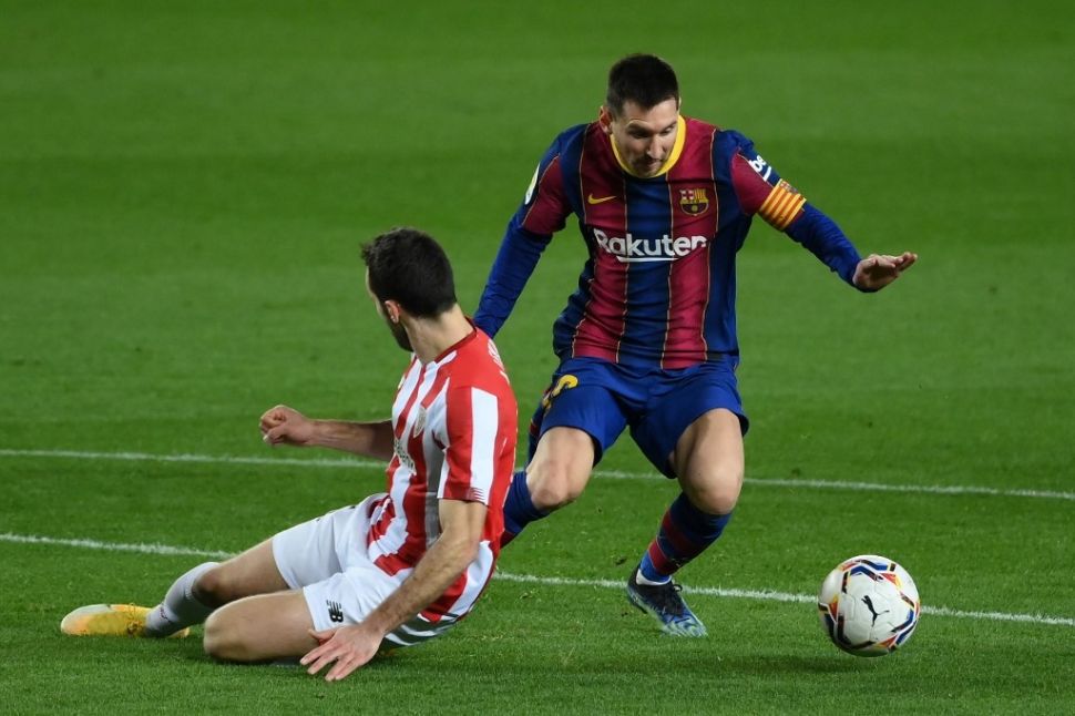 Penyerang Barcelona Lionel Messi coba melewati bek Athletic Bilbao Inago Lekue dalam laga pekan ke-21 Liga Spanyol di Stadion Camp Nou, Senin (1/2/2021) dini hari WIB. LLUIS GENE / AFP