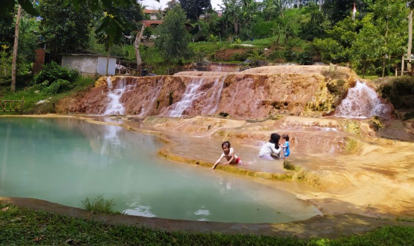 Wisatawan menikmati hangatnya air di Curug Cipanas Kabupaten Bandung Barat. [Suara.com/Ferrye Bangkit Rizki]