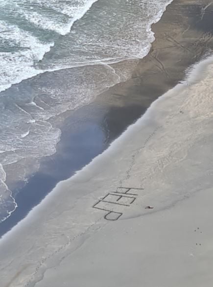 Peselancar minta tolong, tulis 'HELP' lalu pingsan. (surflifesaving.org.nz)