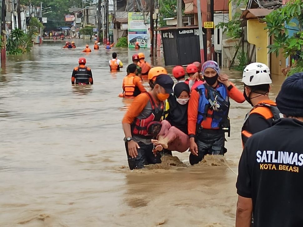 Personel BPBD Kota Bekasi mengevakuasi korban banjir di Perumahan Pondok Gede Permai, Kota Bekasi, Jawa Barat, Jumat (19/2/2021).[Imam/Faishal]