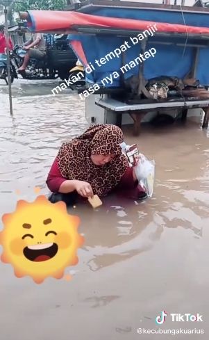 Emak-emak celupkan biskuit ke dalam air banjir. (Tiktok/@kecubungakurius)