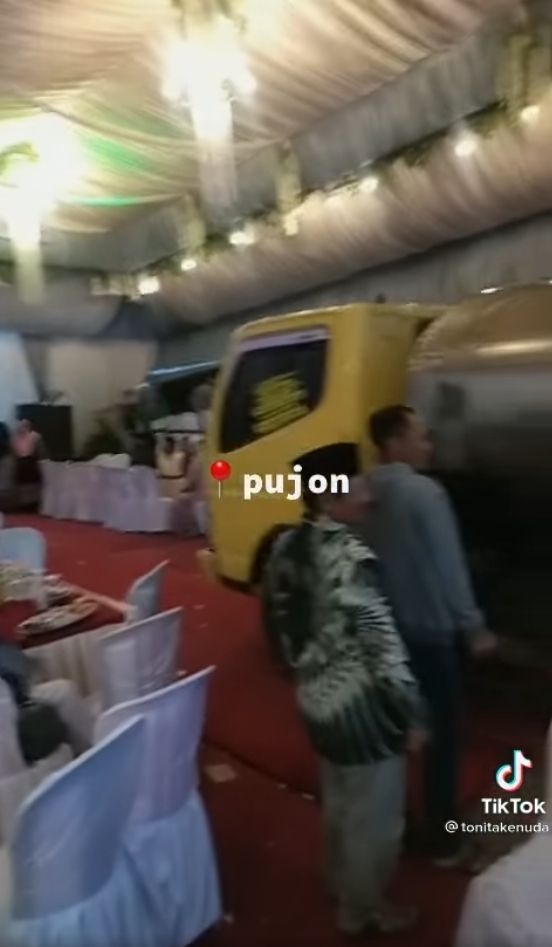 Truk lewat di tengah acara kondangan. (TikTok/@tonitakenuda)