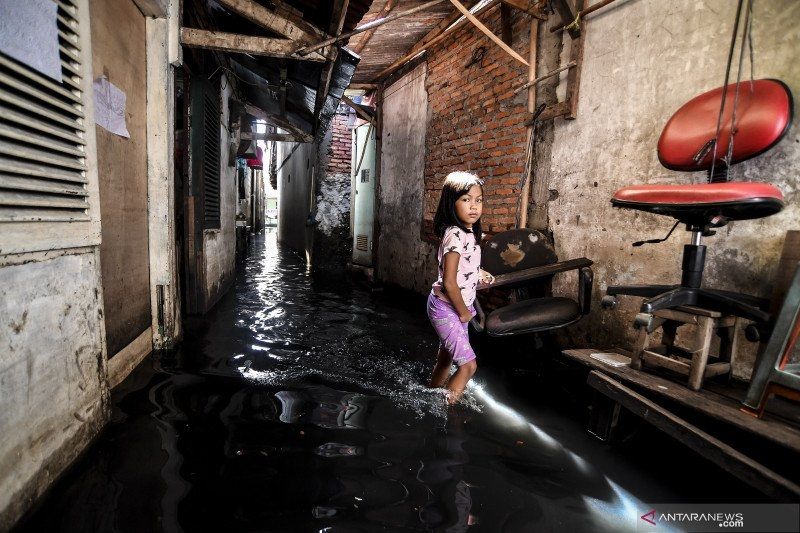 Seorang bocah perempuan berjalan melintasi banjir di kawasan Kedoya Utara, Jakarta Barat, Minggu (21/2/2021). [ANTARA FOTO/Muhammad Adimaja]