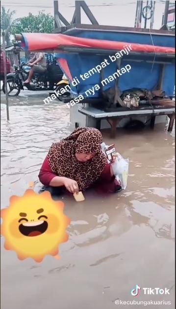 Ibu ini makan biskuit dengan dicelupkan ke air banjir (TikTok @kecubungakuarius)