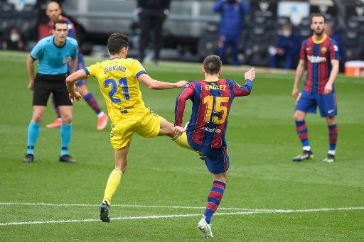 Pemain Barcelona Clement Lenglet berebut bola dengan pemain Cadiz dalam pertandingan Liga Spanyol di Camp Nou, Minggu (21/2/2021). [AFP]