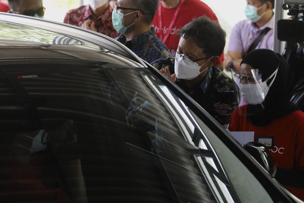 Menteri Kesehatan Republik Indonesia Budi Gunadi Sadikin (kedua kanan) meninjau jalannya vaksinasi COVID-19 dengan sistem 'drive thru'di area parkir Hall C JIExpo Kemayoran, Jakarta, Rabu (3/3/2021). [Suara.com/Angga Budhiyanto]