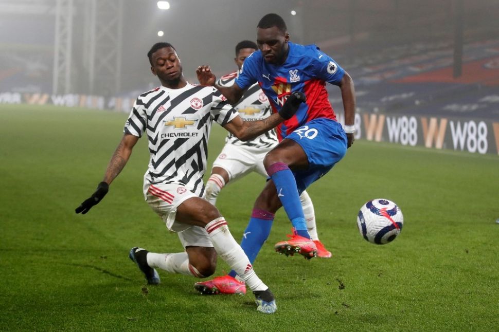 Bek kanan Manchester United, Aaron Wan-Bissaka (kiri) coba merebut bola dari penyerang Crystal Palace Christian Benteke dalam laga lanjutan Liga Inggris di Selhurst Park, London, Kamis (4/3/2021) dini hari WIB. [MATTHEW CHILDS / POOL / AFP].