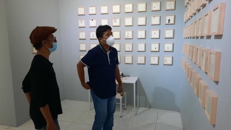 Syam Terrajana (kiri) bersama Pimpinan Redaksi Suara.com, Suwarjono menyaksikan lukisan yang dipamerkan dalam Pameran Tunggal bertema Pada Ruang yang Bercerita di Ruangdalam Art House, Gang Sawo no 55, Padukuhan Jeblog, Kalurahan Tirtonirmolo, Kapanewon Kasihan, Bantul, Jumat (5/3/2021). [Muhammad Ilham Baktora / SuaraJogja.id]