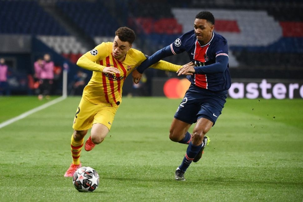 Bek Barcelona Sergino Dest (kiri) memperebutkan bola dengan bek Paris Saint-Germain (PSG) Abdou Diallo dalam pertandingan leg kedua babak 16 besar Liga Champions (PSG vs Barcelona) di Parc des Princes, Paris, Kamis (11/3/2021) dini hari WIB. [FRANCK FIFE / AFP].