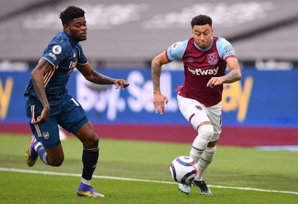 Gelandang serang West Ham United pinjaman dari Manchester United, Jesse Lingard (kanan) dibayangi gelandang jangkar Arsenal, Thomas Partey pada laga Liga Inggris 2020/2021 di London Stadium, Minggu (21/3/2021) malam WIB. [JUSTIN TALLIS / POOL / AFP]