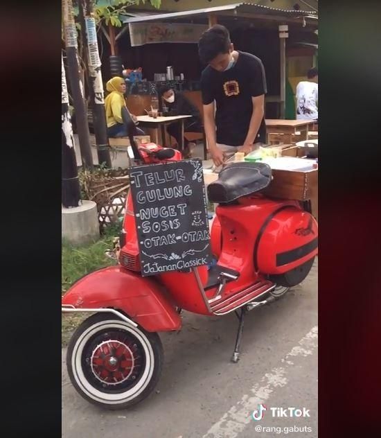 Penjual telur gulung dengan motor Vespa ini menarik perhatian netizen. (TikTok/ @rang.gabuts)