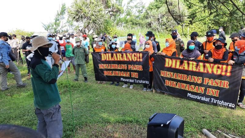 Sejumlah warga Srigading dan  Tirtohargo, membentangkan spanduk penolakan terhadap aktivitas penambangan pasir ilegal di Muara Sungai Opak, Bantul, Minggu (18/4/2021). [Muhammad Ilham Baktora / SuaraJogja.id]