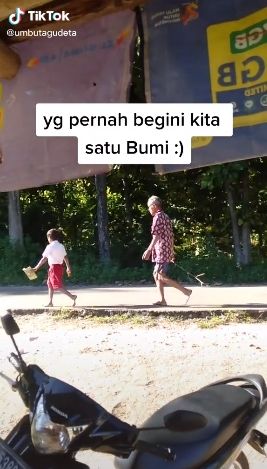 Ayah antar anak ke sekolah tanpa alas kaki. (Tiktok/@umbutagudeta)