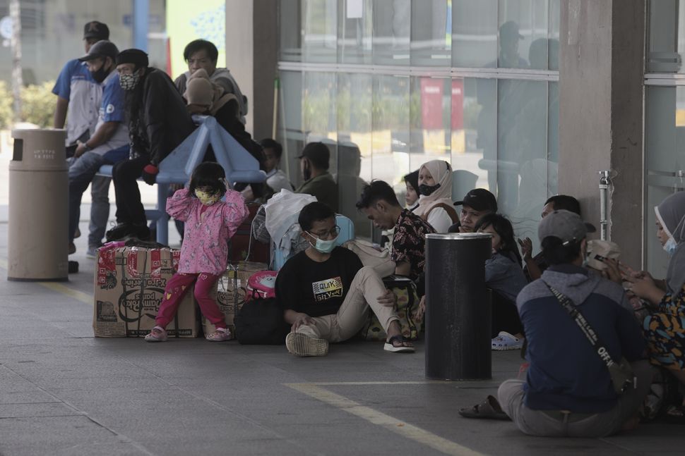 Calon penumpang menunggu kedatangan bus di Terminal Pulo Gebang, Jakarta Timur, Selasa (27/4/2021). [Suara.com/Angga Budhiyanto]