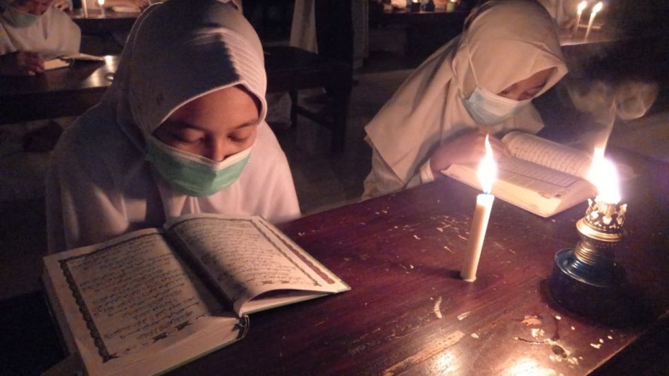 Tradisi unik dalam menyambut malam Lailatul Qadar dilakukan para santri dari Pondok Pesantren Baitul Mustofa, Solo dengan membaca kitab Alquran dengan penerangan kuno sentir, Selasa (4/5/2021) malam. [Suara.com/Budi Kusum]