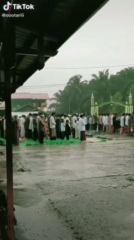 Jamaah salat di tengah hujan. (Tiktok/@oootariii)