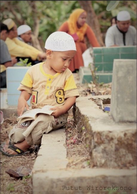 Viral foto anak kecil duduk di samping makam bawa buku yasin (PututWiroreksono).