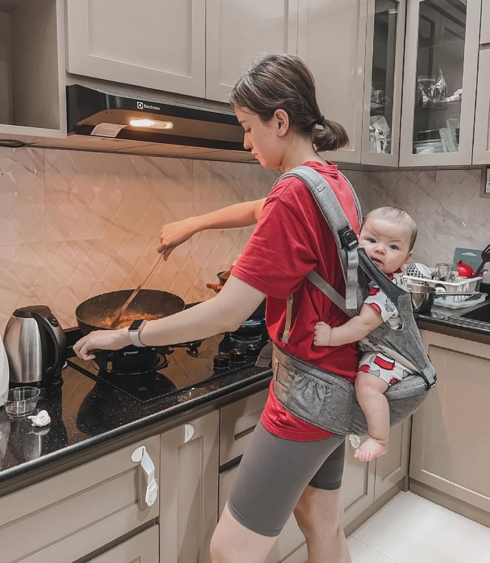 Kimberly Ryder memasak sambil gendong anak. [Instagram]