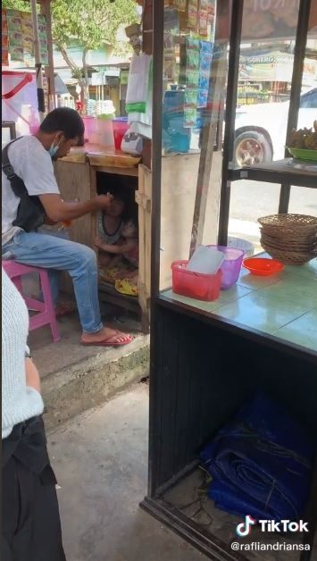 Ayah suapi anak di bawah rombong jualan minuman (TikTok @rafliandriansa)